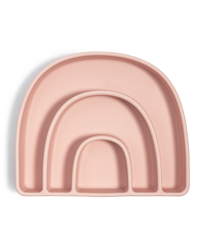 A pink divided plate with a rainbow design, designed for mealtime organization and suction base to attach to surfaces.