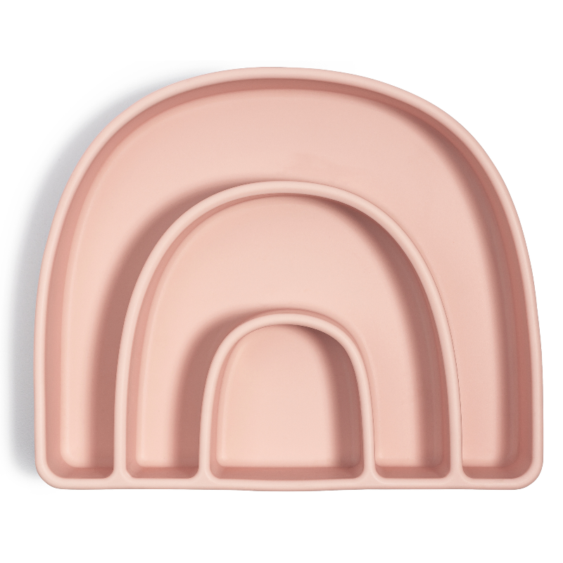 A pink divided plate with a rainbow design, designed for mealtime organization and suction base to attach to surfaces.