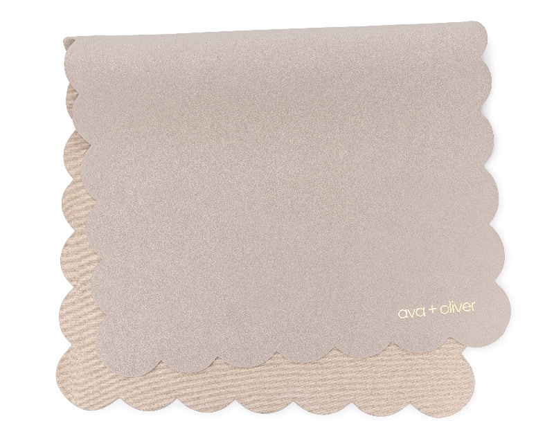 A folded vegan leather changing mat with a grey scallop design.