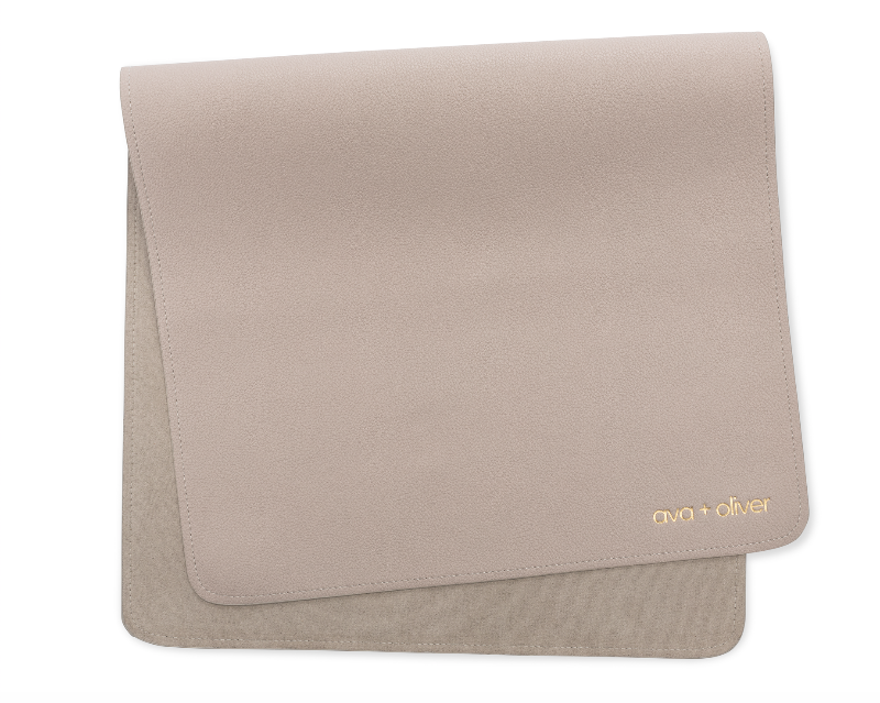 A folded vegan leather changing mat in grey color with the brand name 'ava + oliver' visible on the bottom corner.