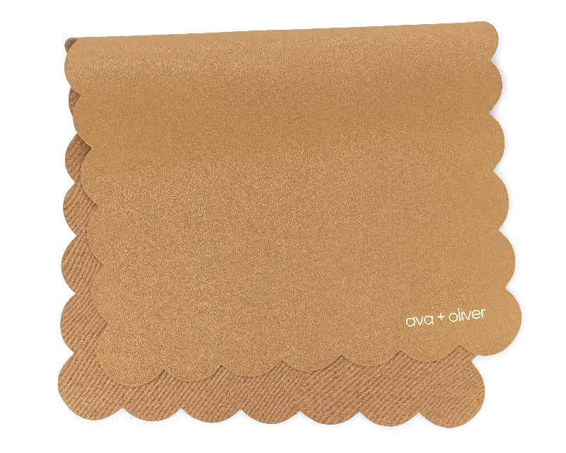A folded vegan leather changing mat in tan color with a scallop edge design.