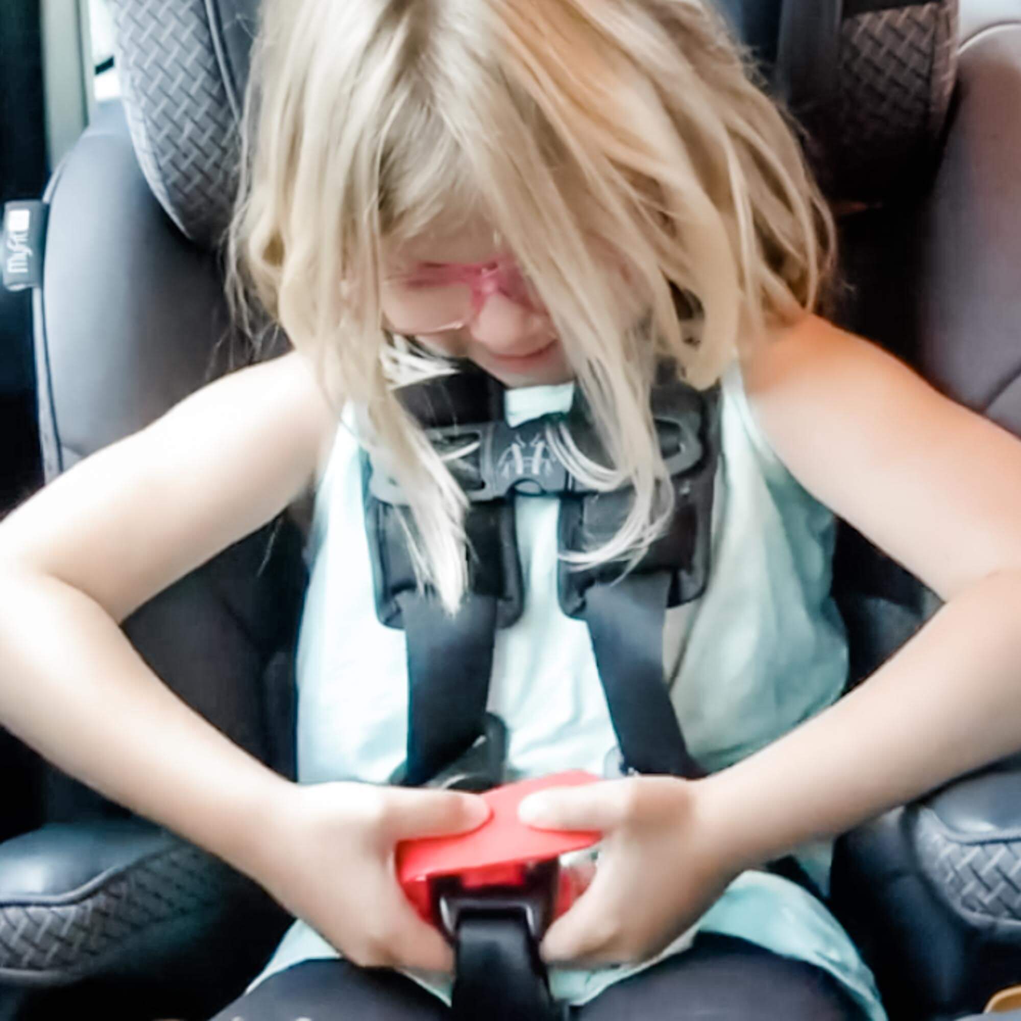 Child using a car seat buckle release helper